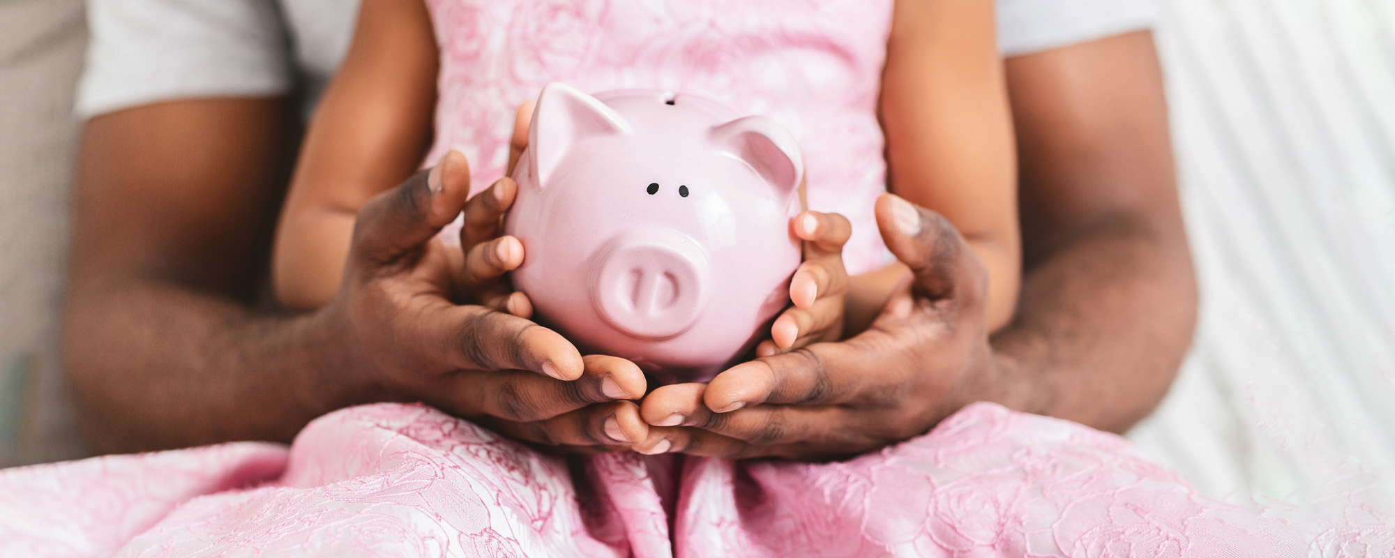 father and daughter holding piggy bank