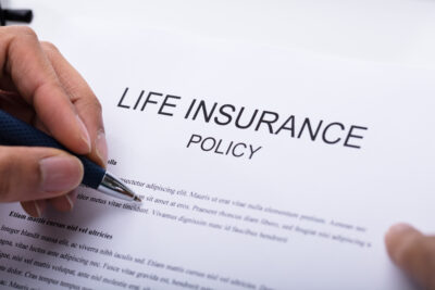 life insurance policy contract pen in hand
