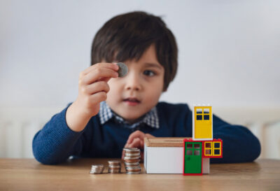child support child with coins in hand playing with lego toy